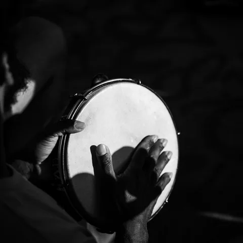 Mãos tocando pandeiro, imagem ilustrativa
